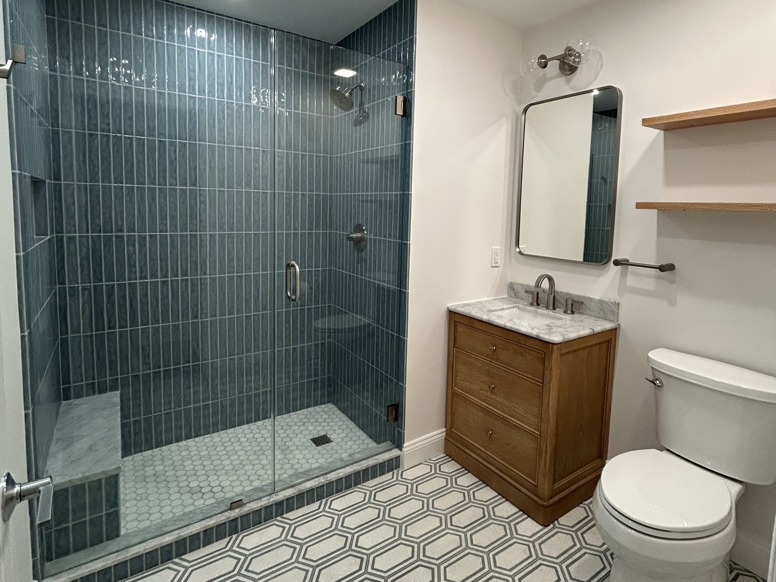 Teal tile shower and wood vanity